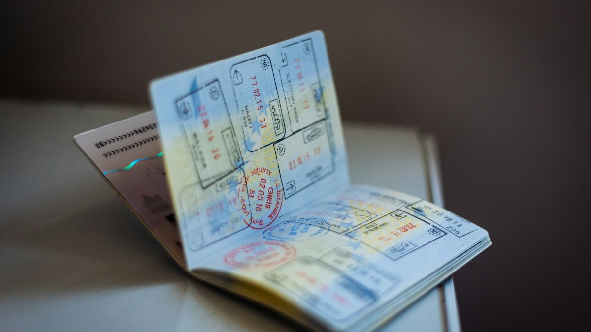 An open passport with pages full of colourful visa and entry stamps